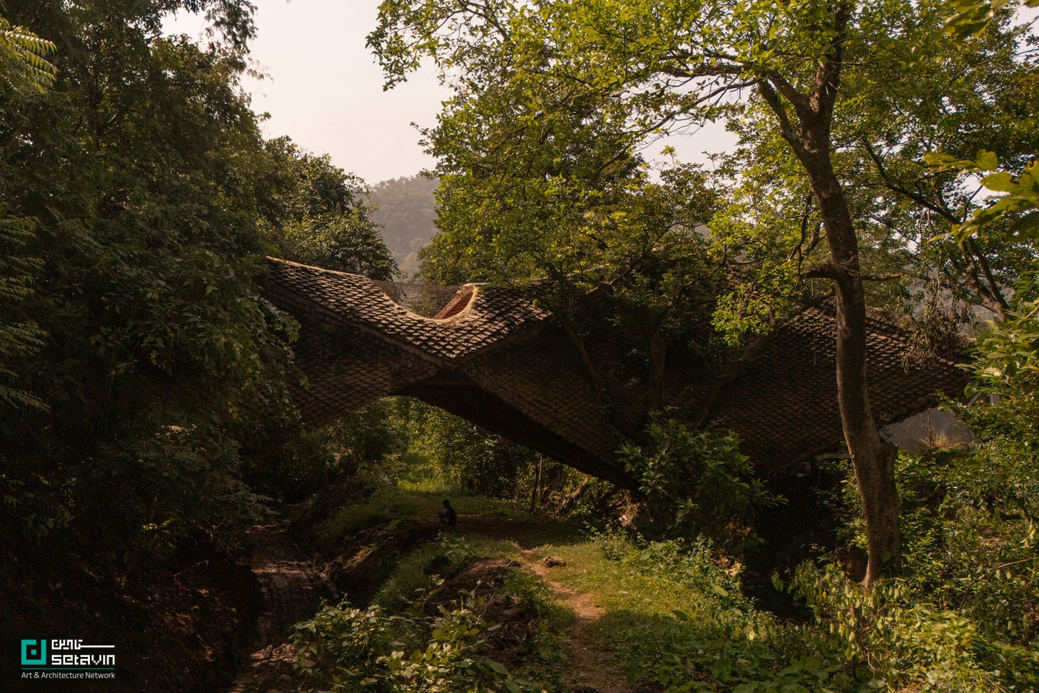 معماری پایدار، خانه پل، Wallmakers، سازه معلق، معماری هند، وینو دنیل، پل مسکونی، طراحی با مصالح بومی، سازه سبک، کاه‌گل مدرن، معماری طبیعت‌گرا، معماری معاصر آسیا، بازاستفاده مصالح، ستاوین، پروژه‌های شاخص معماری , Bridge House, Wallmakers, Vinu Daniel, Karjat architecture, sustainable residential design, suspension bridge house, hyperbolic parabola structure, vernacular materials, mud-thatch composite, reclaimed wood interiors, nature-integrated architecture, Setavin Architecture Network