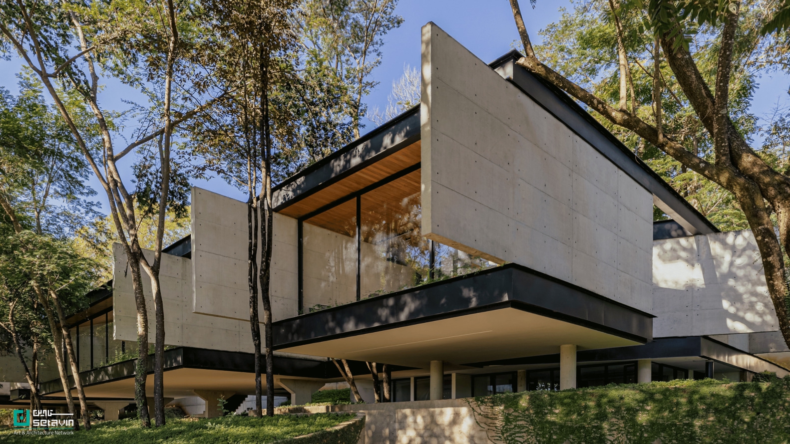 خانه آدنتِرو (Adentro House) در برزیل اثر دفتر معماری TETRO؛ سازمانی افقی و مدرن با حفظ کامل درختان کهن و تاکید بر پویایی فضاهای پر و خالی.